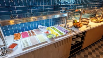 Un bufé con diversos alimentos y utensilios.
