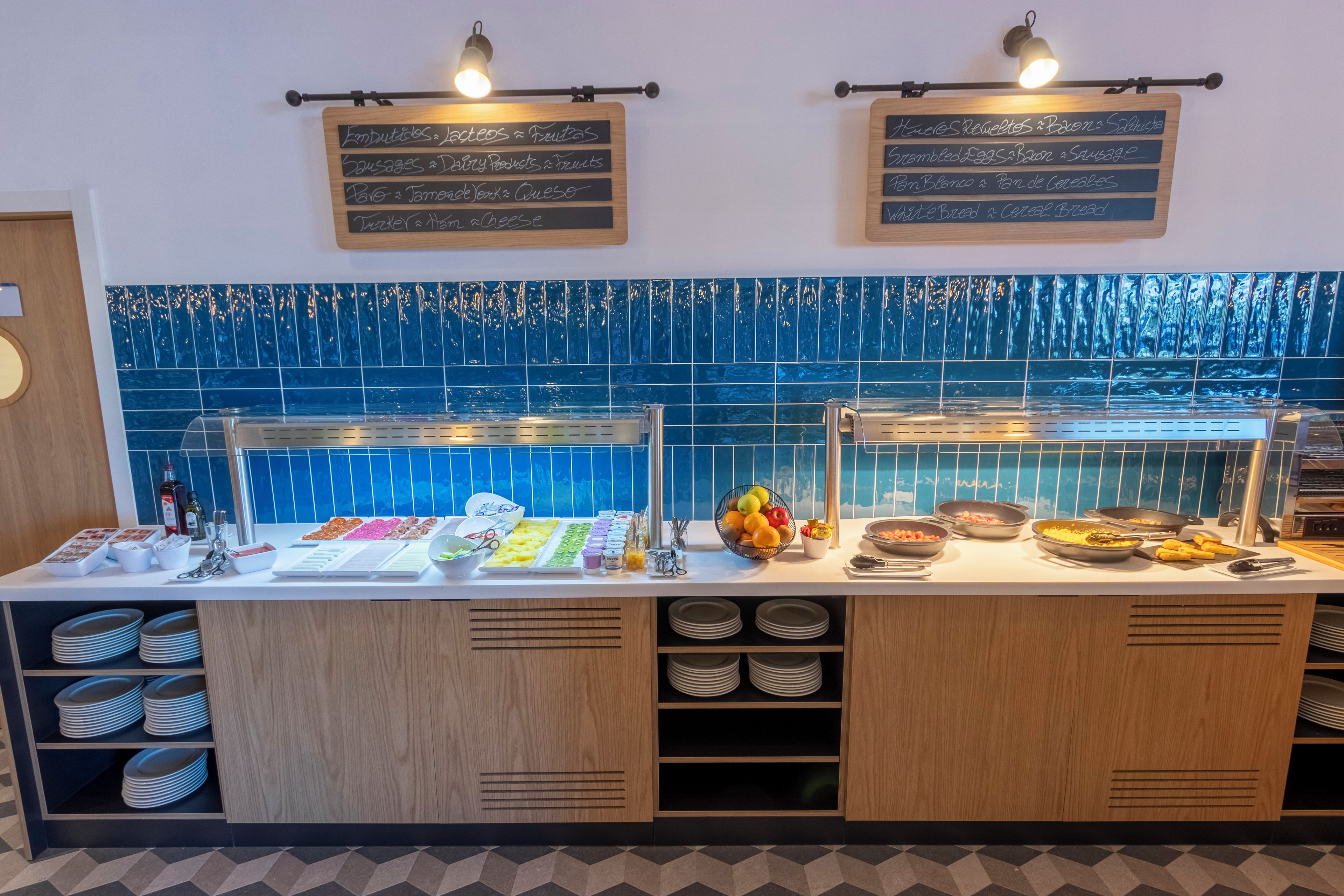 Un mostrador de buffet con diferentes opciones de comida y un menú en una pizarra.