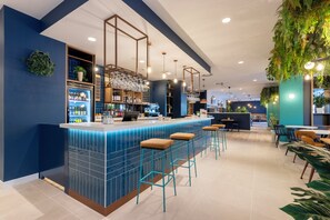 A bar area with stools, shelves with bottles, and hanging lights. - Travelodge Bilbao Sestao (Sestao)