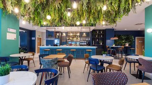 Ein Restaurant mit hängenden Pflanzen, einer Bar und verschiedenen Sitzgelegenheiten.