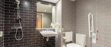 A modern bathroom with a black and grey tiled wall, a white sink, a toilet, and a shower.