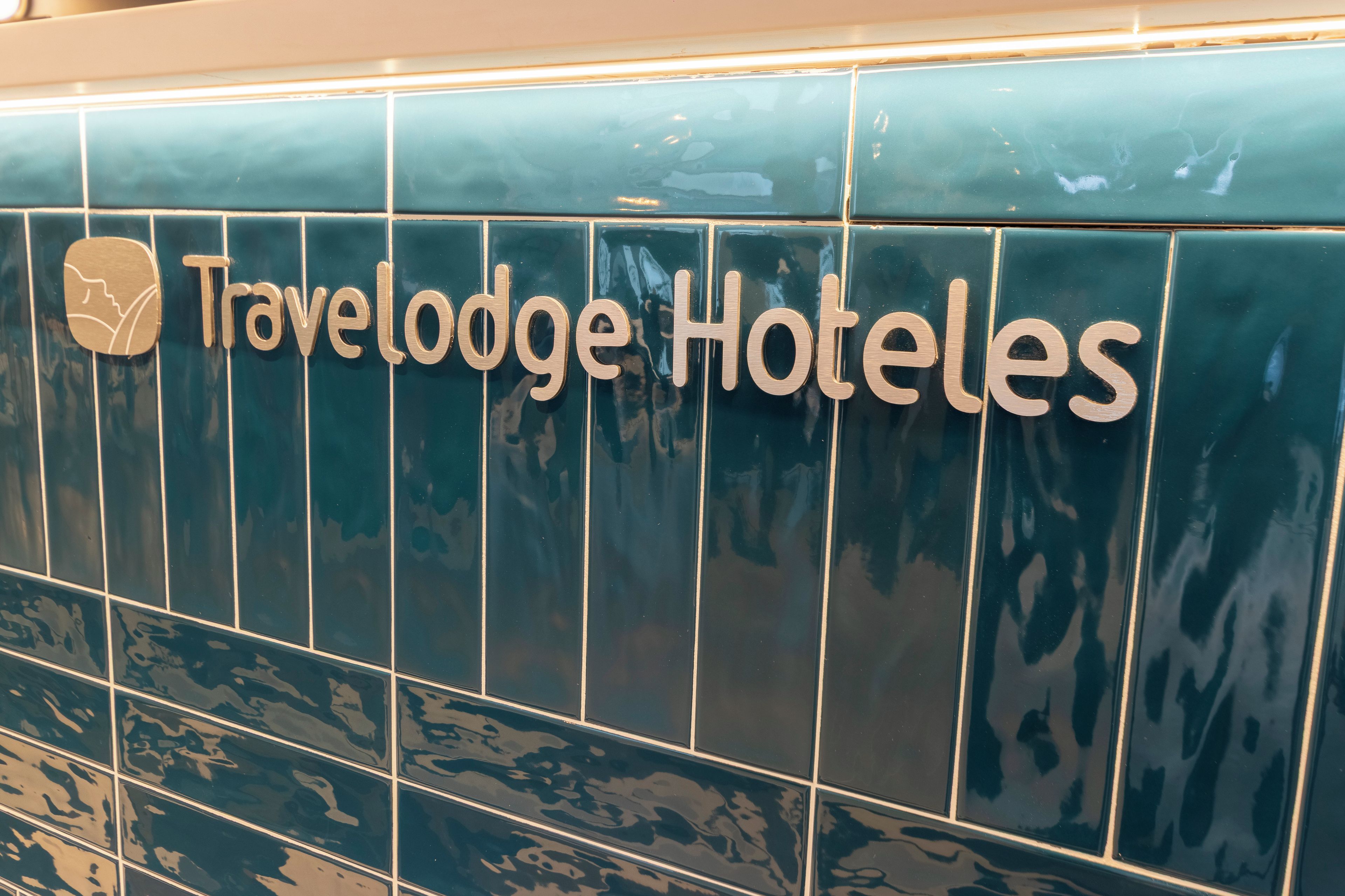 A tiled wall with the text 'Travelodge Hotels' and a logo.