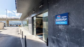 Una entrada de hotel moderna con un letrero que dice 'Hoteles Travelodge Bilbao Sestao'.