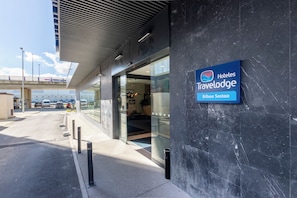 Een moderne hotelentree met een bordje met de tekst 'Hoteles Travelodge Bilbao Sestao'.