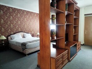 Une chambre à coucher avec un lit, une armoire en bois et une table de chevet avec une lampe.