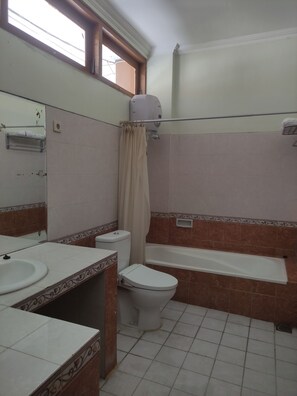 Une salle de bain avec des toilettes, un lavabo et une baignoire.