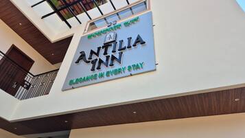 A hotel sign with the name 'ANTILIA INN' and the tagline 'Elegance in every stay.'