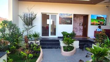 A multi-level building with a central courtyard, balconies, and a variety of plants.