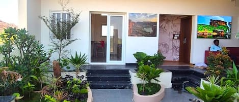 Un immeuble à plusieurs étages doté d’une cour intérieure, de balcons et d’une grande variété de plantes.