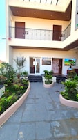 Un edificio de varios niveles con un patio central, balcones y diversas plantas.