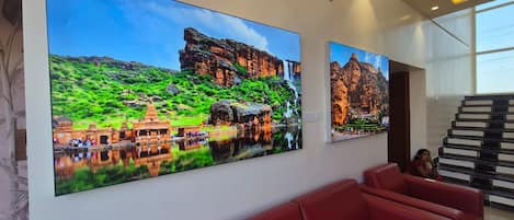 A modern interior with a large wall-mounted artwork depicting a temple complex and a staircase.