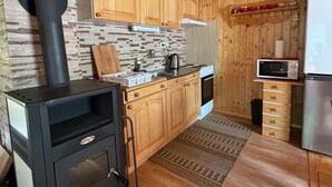 A compact kitchen with wooden cabinets, a built-in stove, a microwave, and a refrigerator.