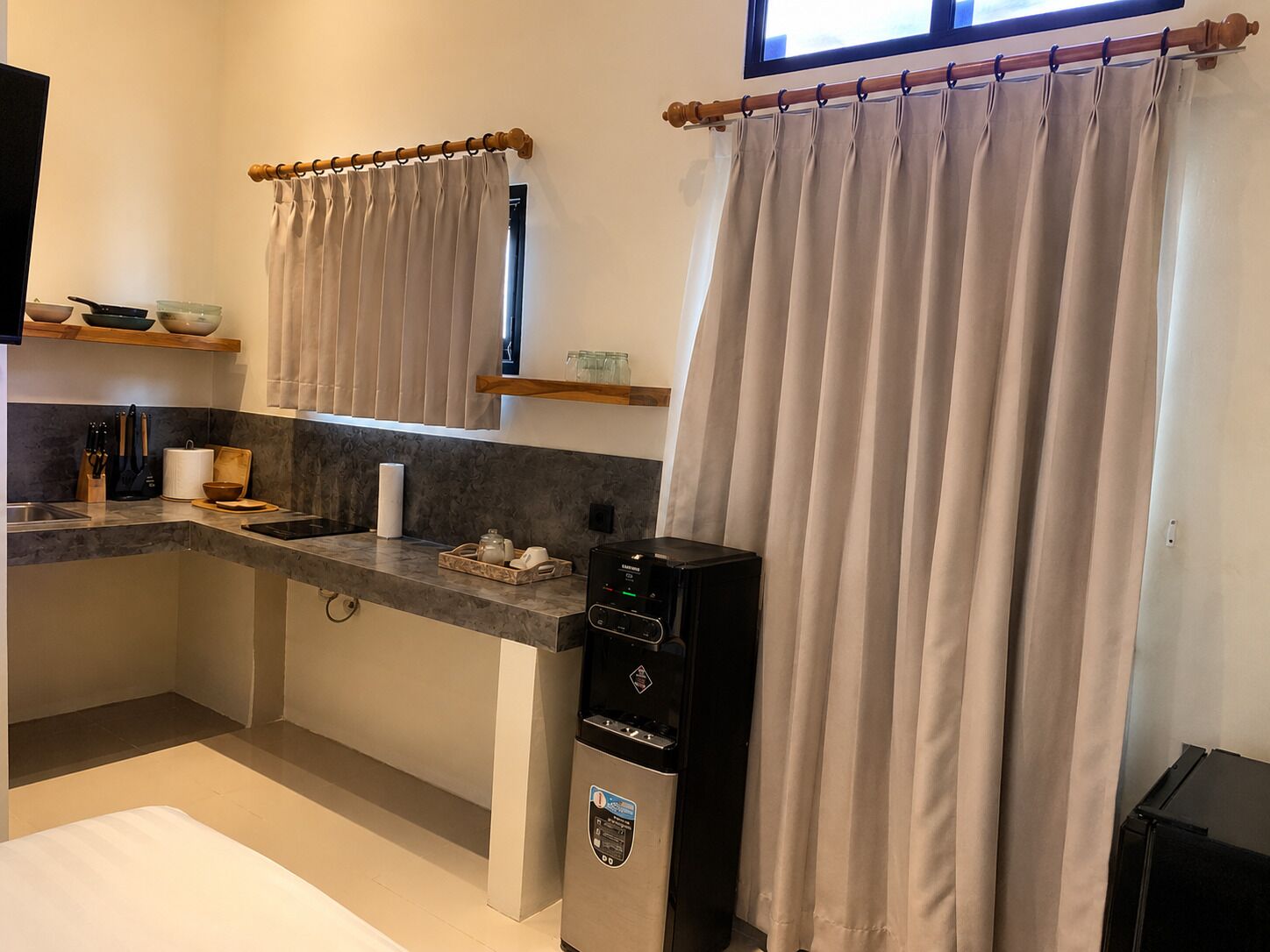 Une cuisine compacte équipée d’un four à micro-ondes encastré, d’une machine à café et d’un petit plan de travail.