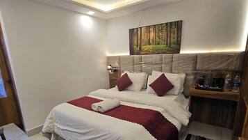 A hotel room with a bed, a nightstand, a painting, and a headboard.