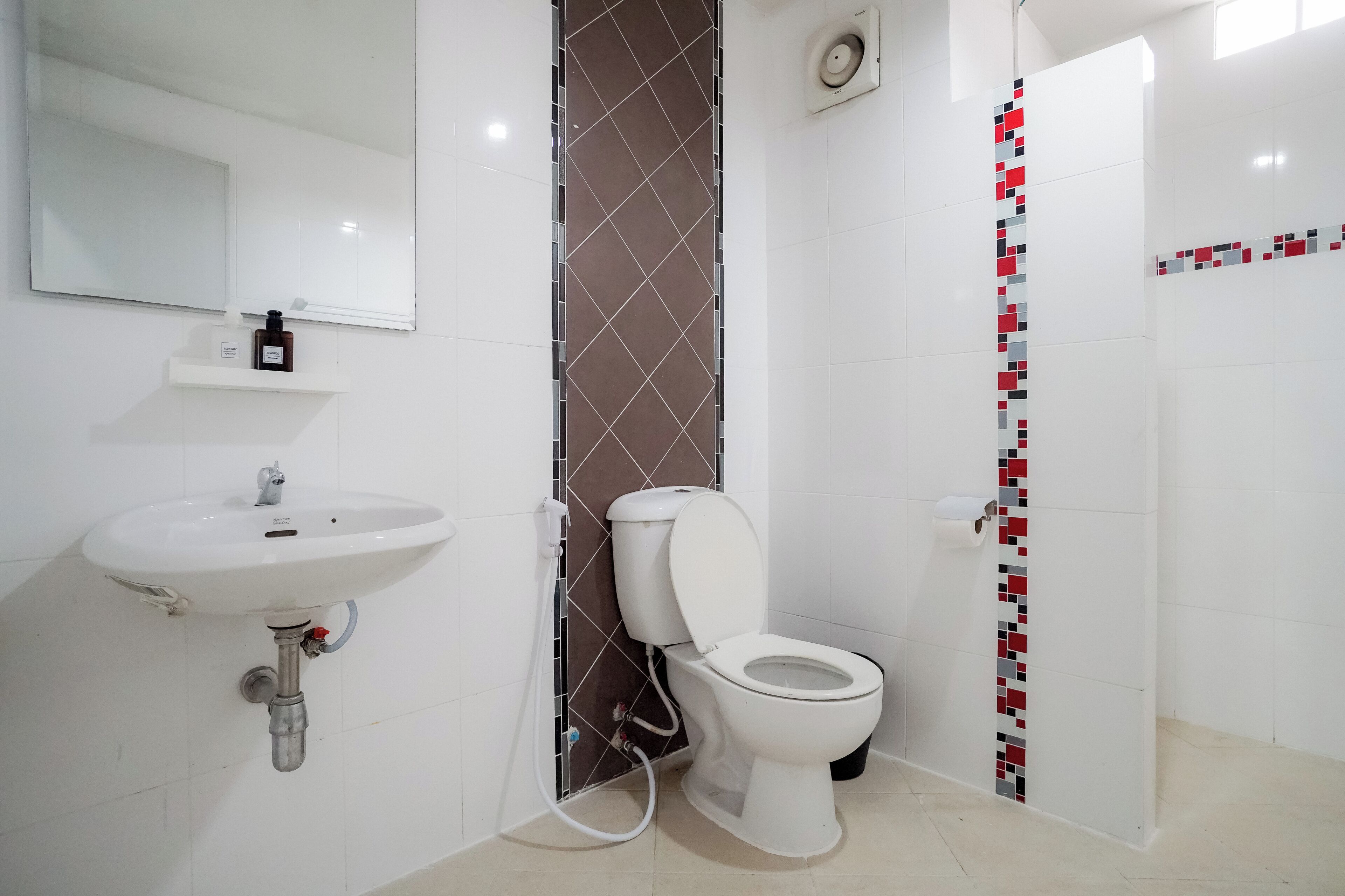 Un baño con lavamanos, inodoro y ducha.
