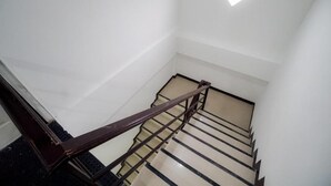 A staircase with a handrail and a small window at the top. - NP Place Santitham (Chiang Mai)
