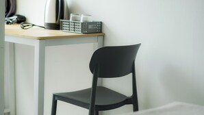 A chair and a table with a kettle and a basket of items. - NP Place Santitham (Chiang Mai)