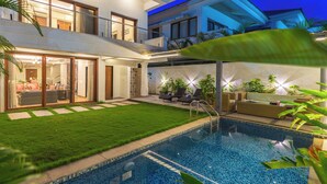 A modern two-story house with a swimming pool, a covered patio, and a well-maintained lawn. - ELIVAAS Azalea 3 BHK with Pvt Pool (Siolim)