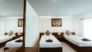 A hotel room with two beds, a wooden headboard, a wall-mounted artwork, and a mirror. - Snap Inn Thaphae (Chiang Mai)