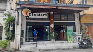 A building with a sign for 'DIABLO'S BURRITOS' and another sign for 'Tea Coffee Rooms Indian Cuisine Food Rooftop Cafe'. - Snap Inn Thaphae (Chiang Mai)
