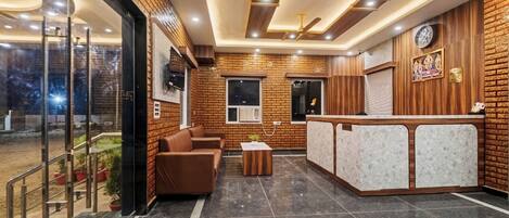 A lobby with a reception desk, seating area, and a glass entrance.