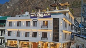 Een meerhoog hotel met een bord waarop staat 'HOTEL ROYAL BADRI Badrinath'.