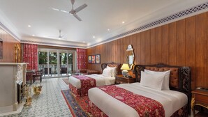 Une chambre d’hôtel avec deux lits, un balcon, une cheminée et une vue sur l’extérieur.