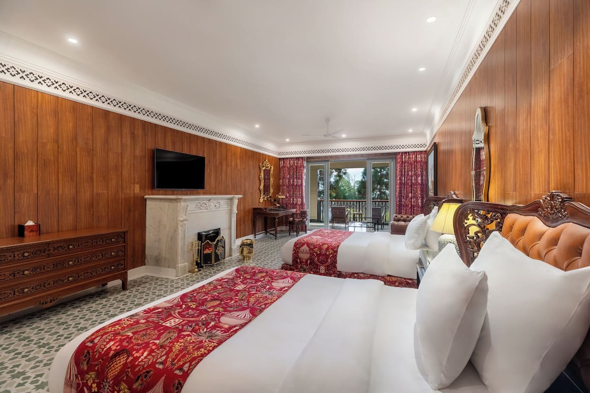 Une chambre d’hôtel avec deux lits, une télévision, une cheminée et un balcon avec vue.