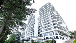 Un moderno edificio de gran altura con varios balcones y ventanas amplias.