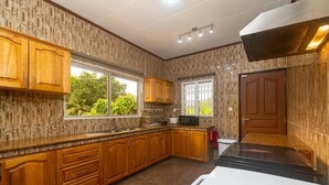 Une cuisine avec des meubles de rangement en bois, un four à micro-ondes et une cuisinière.