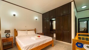 Une chambre à coucher avec un lit en bois, des tables de chevet, une commode et un miroir.