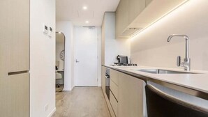 Una cucina moderna con lavello in acciaio inossidabile, forno integrato e microonde.