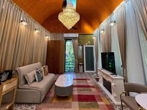 Amplia sala de estar con sofá, mesa de centro, televisor y chimenea.