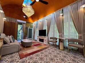 Una sala de estar amplia con chimenea, televisor y ventilador de techo.