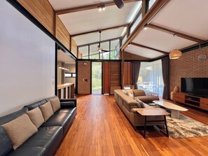 Una sala moderna con un sofá, una mesa de centro y un televisor.
