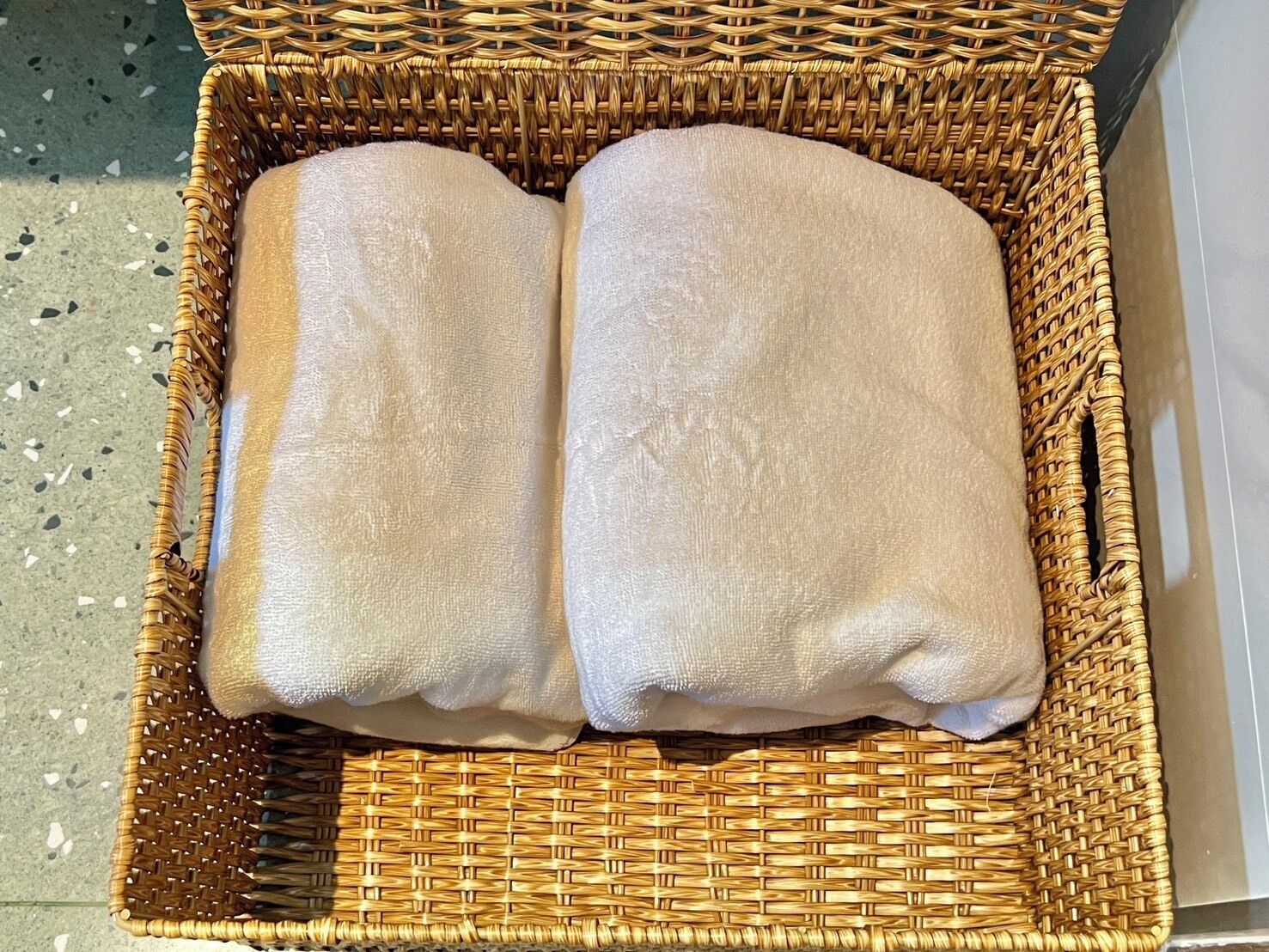 Una cesta de mimbre con dos toallas dobladas.