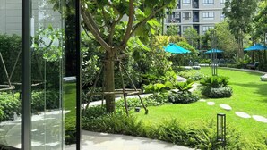 A fitness room sign, a building with balconies, and a well-maintained garden with pathways. - Dcondo Reef  kathu Patong (Kathu)