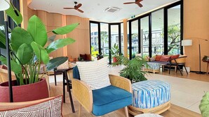A spacious room with large windows, ceiling fans, and comfortable seating. - Dcondo Reef  kathu Patong (Kathu)