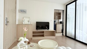 A modern living room with a TV, sofa, and coffee table. - Dcondo Reef  kathu Patong (Kathu)