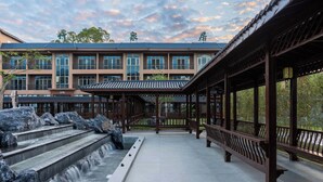 Un bâtiment de style traditionnel agrémenté d’un élément aquatique et de passerelles en bois.