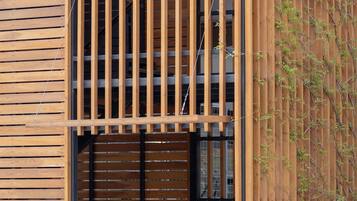 A modern building with a wooden facade, a large garage door, and two bicycles parked outside.