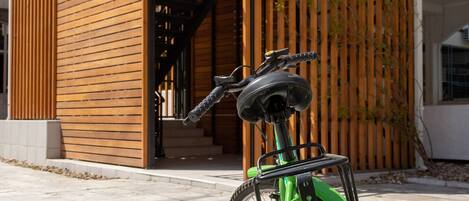 Un edificio moderno con fachada de madera y una bicicleta verde estacionada adelante.