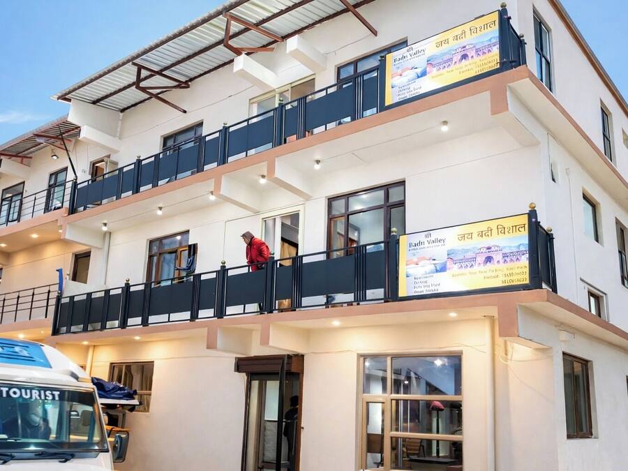 A multi-story hotel with balconies, a visible entrance, and a signboard.