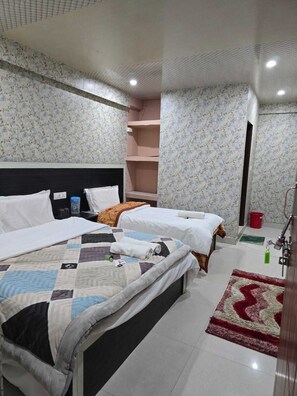 Une chambre d’hôtel avec deux lits, une grande fenêtre, un tapis rouge et une salle de bain avec douche.