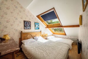 A bedroom with a skylight, a wooden headboard, a bed with white bedding, a bedside table, and a lamp. - Etretat sight Beach cliffs Golf - 332m2 13pers, 232m2 8pers, 107m2 5pers - 4str (Étretat)