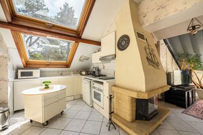Une cuisine dotée d’une lucarne, d’un four à micro-ondes, d’une cuisinière et d’un évier.