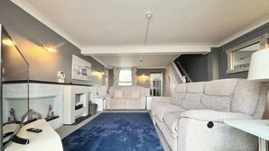 Ein modernes Wohnzimmer mit einer Couch, einem Couchtisch und einem Kamin.