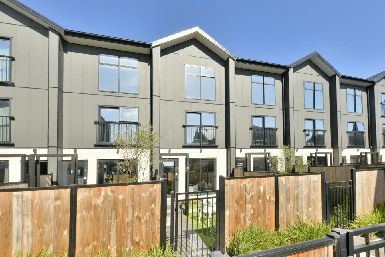 Un immeuble d’appartements moderne, doté de nombreux logements, chacun offrant des balcons et de grandes fenêtres.