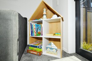 Ein Eckenregal mit Kinderbüchern und Spielzeug.