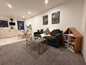 Ein modernes Wohnzimmer mit einer Couch, einem Couchtisch und einem Bücherregal.